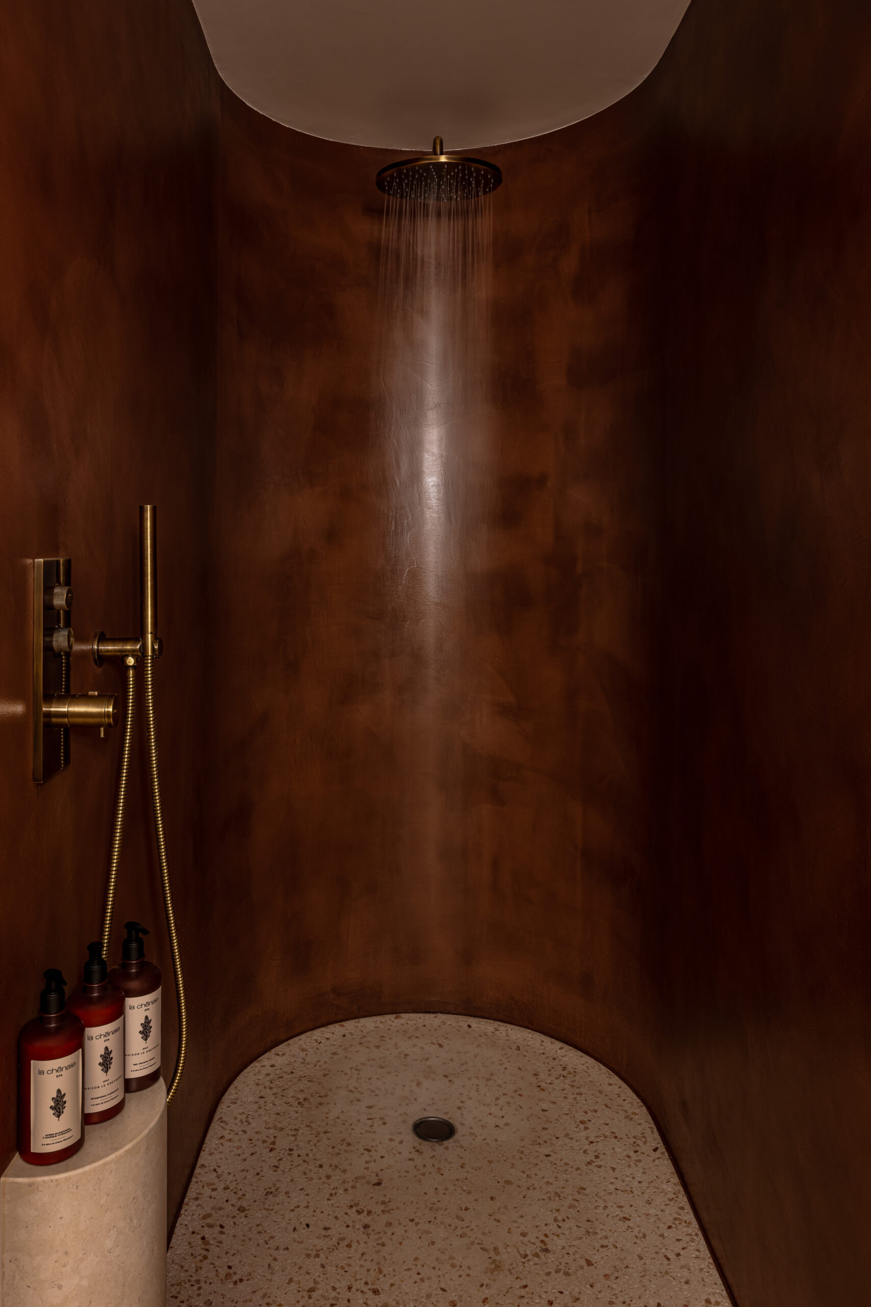Douche en béton ciré ; douche sans joint ; Hôtel aison Le Chevreuil ; Hotel Meursault ; Hôtel en béton ciré ; hôtel Le Chevreuil ; salles de bain en béton ciré de chaux ; béton ciré de chaux ; Betostuc  Dolci ; élégance douche ; béton ciré lie de vin ; douche en forme de fût ; le thème du vin décliné jusque dans la douche ; suite de l'hôtel Le Chevreuil en Bourgogne ; Le charme des arrondis ; la douceur du béton ciré ; la finesse et l'élégance du béton ciré dans les douches de l'hôtel  